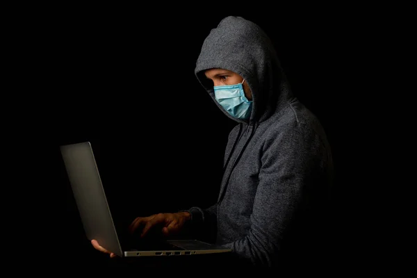 Pria Bertopeng Dan Tudung Memegang Laptop Tangannya Dengan Latar Belakang — Stok Foto