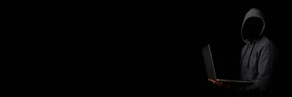 Человек Лица Капюшоне Держит Ноутбук Тёмном Фоне Концепция Кибер Мошенника — стоковое фото