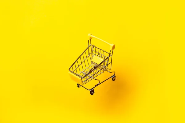 Leere Einkaufswagen Fliegen Der Luft Auf Leuchtend Gelbem Hintergrund Nahaufnahme — Stockfoto