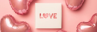 Pastel pembe arka planda hediye kutusu ve hava balonu. Beste Sevgililer Günü. Düz yerde, üst tarafta. Pankart.