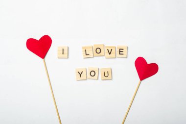 Beste Sevgililer Günü. Sopadaki kalpler ve pembe arka plandaki tahta plaklardan gelen mesajlar. Pankart. Düz yatış, üst görünüm.