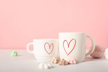 Sevgililer Günü için şenlik kompozisyonu. Pembe arka planda kupalar ve tatlılar. Pankart.