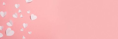 Beyaz kalpler pembe arka planda kağıttan kesilmiş. Sevgililer Günü 'nün kompozisyonu. Pankart. Düz yatış, üst görünüm.