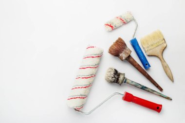 Beyaz arka planda boya fırçaları ve silindirler. Pankart. Düz yatış, üst görünüm.