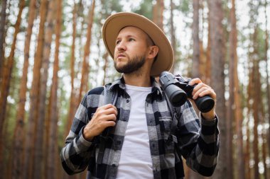 Ormanda yürürken dürbünlü bir turist. Dağlarda ya da ormanlarda yürüyüş.