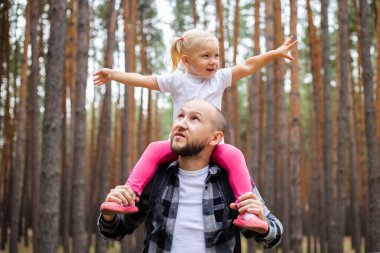 Babasıyla bir çocuk ormanda yürüyüş yaparken. Aile dağlara ya da ormana gider..