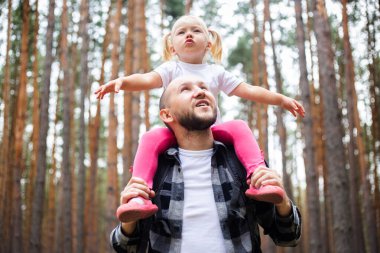 Babasıyla bir çocuk ormanda yürüyüş yaparken. Aile dağlara ya da ormana gider..