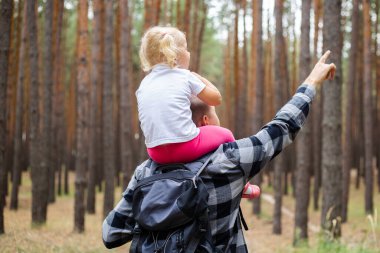 Babasıyla bir çocuk ormanda yürüyüş yaparken. Aile dağlara ya da ormana gider..