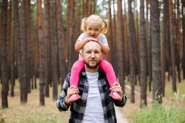 Babasıyla bir çocuk ormanda yürüyüş yaparken. Aile dağlara ya da ormana gider..