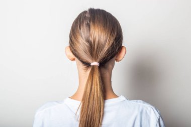 Girl with protruding ears, back view on a light background clipart