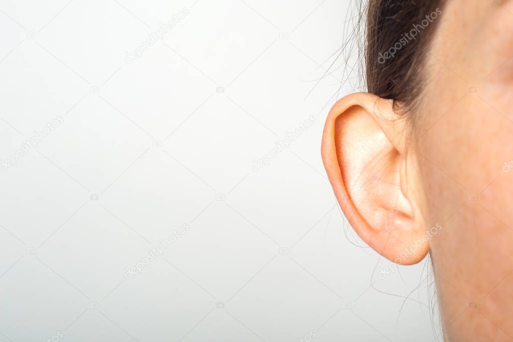 Female ear, lop-eared, protruding, close-up on a light background. Auricle defect