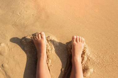 Bebeğim kumsalda, kumsalda iki ayak uzan. Seyahat, tatil