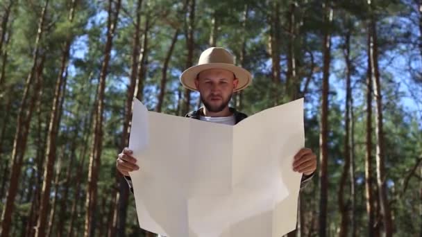 มนุษย์นักปีนเขาปรึกษาแผนที่ในป่า องค์ประกอบการเดินป่า . — วีดีโอสต็อก