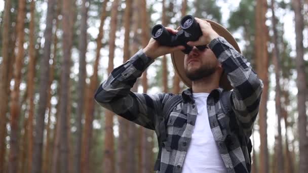 Férfi turista távcsővel, miközben túrázik az erdőben vagy a hegyekben. Turisztikai koncepció. — Stock videók