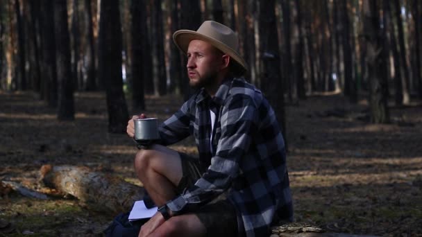 Man hiker drinks tea during a halt in the forest. Concept hike, tourism. — Stock Footage Man hiker drinks tea during a halt in the forest. Concept hike, tourism. Royalty Free Stock Footage