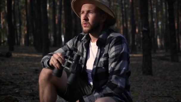 Jeune homme se reposant et regardant à travers les jumelles pendant la randonnée — Video