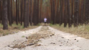 Genç adam ormanda koşuyor. Dar odak.