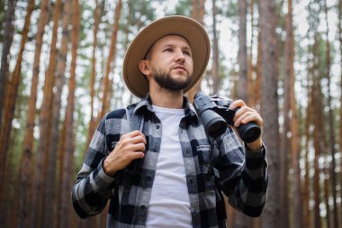 Ormanda dürbünlü bir adam. Dağlarda ya da ormanlarda yürüyüş.