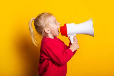 Çocuk, parlak sarı bir arka planda beyaz bir megafona bağırıyor..