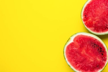 Taze kırmızı, parlak sarı arka planda iki yarım karpuz..