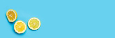 Mavi arka planda sulu taze üç limon dilimi. Üst manzara, düz yatış. Pankart.