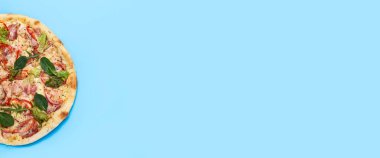 Pizzanın sıcaklığı mavi arka planda. Üst manzara, düz yatış. Pankart.