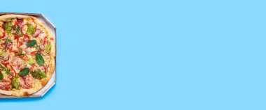 Pizzalar taze ve mavi arka planda paketlenmiş. Üst manzara, düz yatış. Pankart.