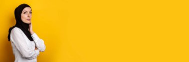 Sarı arka planda gülümseyen tesettürlü genç Müslüman kadın. Pankart.