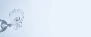 Mavi arka planda boş cam kadehler. Üst manzara, düz yatış. Pankart.