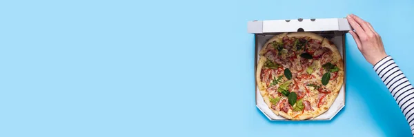 Main Féminine Ouvrir Paquet Pizza Sur Fond Bleu Vue Dessus — Photo