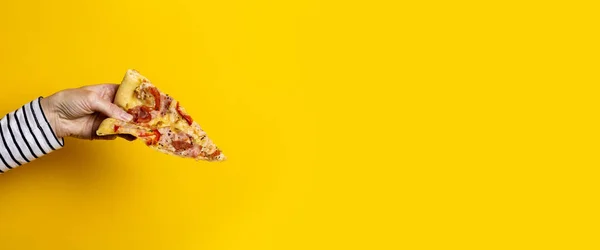 Жовтому Фоні Жіноча Рука Тримає Шматочок Свіжої Гарячої Піци Банер — стокове фото