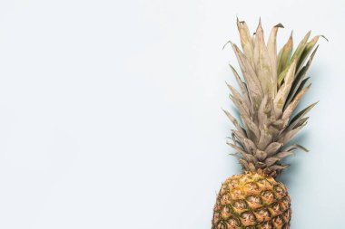 Hafif bir arkaplanda olgun bir ananas. Üst manzara, düz uzanma.