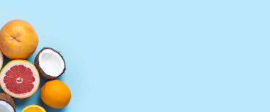 Mavi arka planda egzotik meyveler. Hindistan cevizi, portakal, greyfurt. Üst manzara, düz yatış. Pankart.