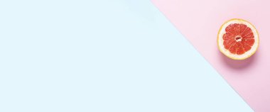 Pembe ve mavi arka planda dilimlenmiş greyfurt. Pankart. Düz yatış, üst görünüm.