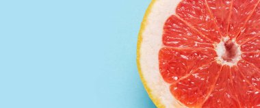 Mavi arka planda yarım greyfurt. Yakın plan. Yaz arkaplanı kavramı, duvar kağıdı. Pankart. Düz yatış, üst görünüm.