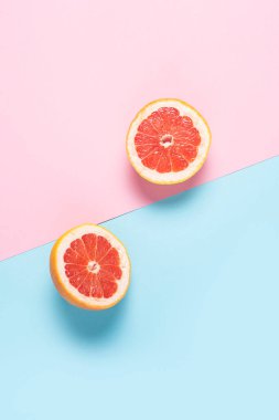 Pembe ve mavi arka planda dilimlenmiş greyfurt. Pankart. Düz yatış, üst görünüm.