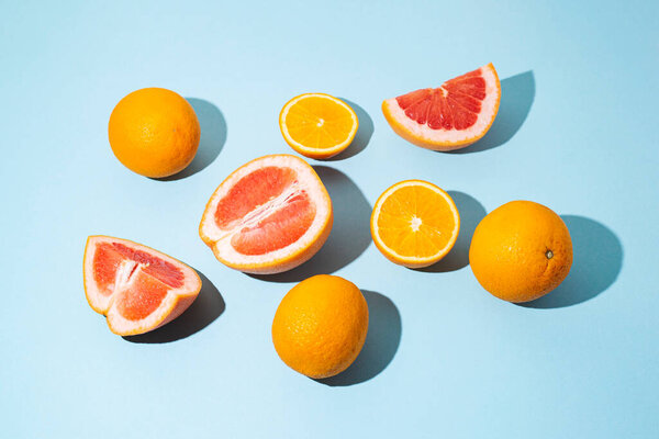 citrus fruits, oranges, grapefruit on a blue background. Top view, flat lay.