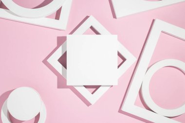 Beyaz sunum, pembe arka planda geometrik şekiller sunar. Üst manzara, düz uzanma.