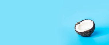 Hindistan cevizi beyazı. Mavi arka planda yarım açık hindistan cevizi. Pankart.