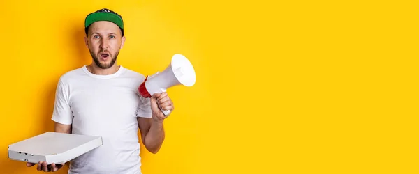 Screaming Young Man Megaphone Holding Packaged Pizza Yellow Background Banner — Stock Photo, Image