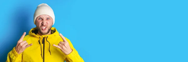 Bearded Young Man Yellow Jacket Shows Rocker Goat Horn Blue — Stock Photo, Image