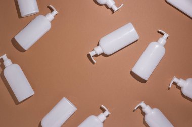 Kahverengi karton arka planda şeker kutulu beyaz şişeler var. Üst manzara, düz uzanma.