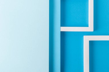 Katlanmış kağıt malzemelerin mavi karton tasarımının arka planında kare podyumlar. Üst manzara, düz uzanma.