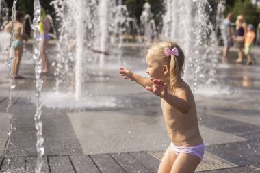 Şehir jetfıskiyelerinde su sıçratarak oynayan tatlı küçük kız..