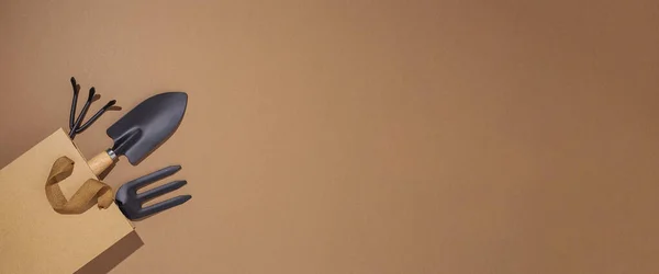 茶色の背景にギフトバッグにガーデニングツール トップビュー フラットレイアウト バナー — ストック写真
