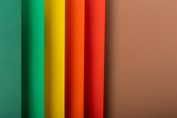 Цветной фон вертикальный из сложенного бумажного материала. Вид сверху, плоский.