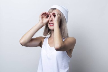 Dürbün şeklinde, hafif arka planda parmakları olan neşeli genç bir kadın..