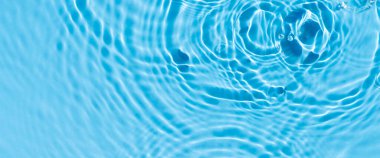 Güneş ışığı altında mavi suya damlalar ve ampuller. Üst manzara, düz yatış. Pankart.