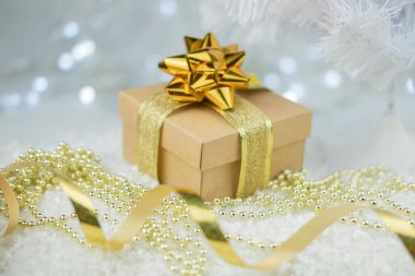 Hediye kutuları, altın rengi bir fiyonk ve süslemelerle dolu. Yeni yıl için karlı zeminde oyuncak topları var.