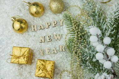 Hediyeler ve altın renkli oyuncaklar kardaki bir Noel ağacında düzlük içinde duruyor. Tebrik mektuplarıyla birlikte.